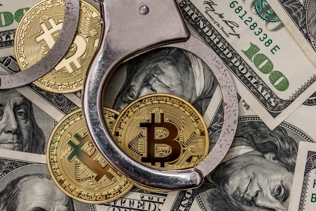 handcuff with dollar and bitcoin. close up