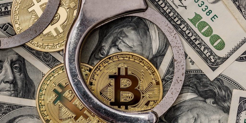 handcuff with dollar and bitcoin. close up