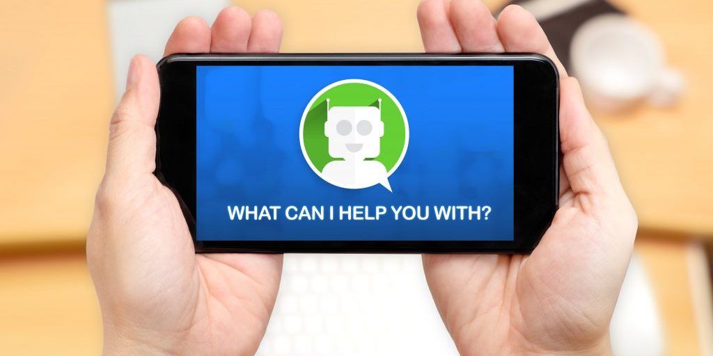 Watching two hand holding mobile phone with Chat bot and what can i help you with? with blur desk office background,Digital marketing concept.