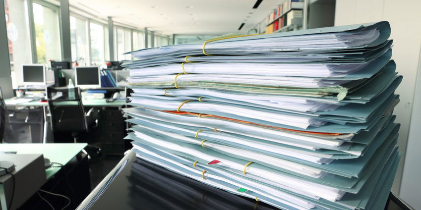 documents stack with blurred office in background