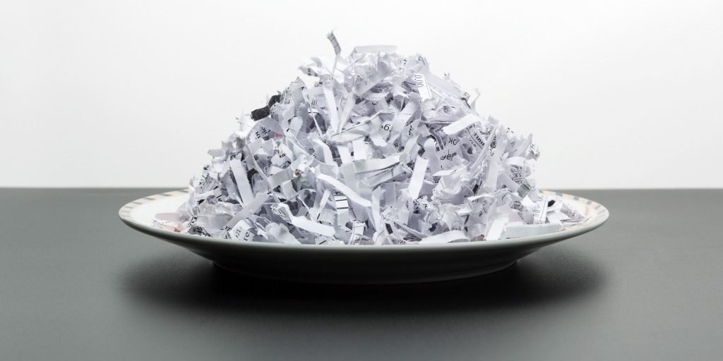 Plate of heap of white shredded papers isolated on white